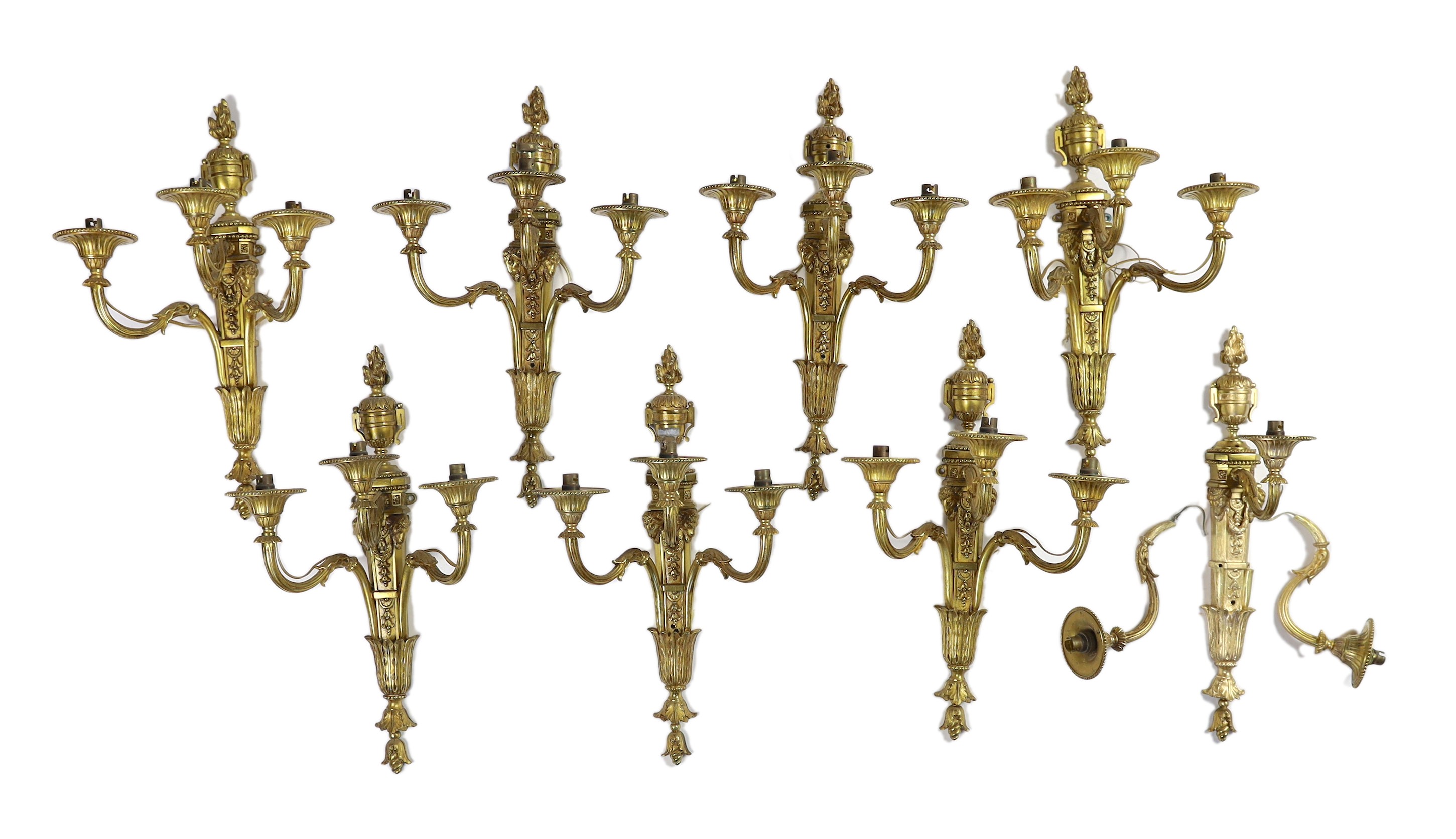 A set of eight cast gilt brass three branch wall sconces Height 23cm Width 22cm